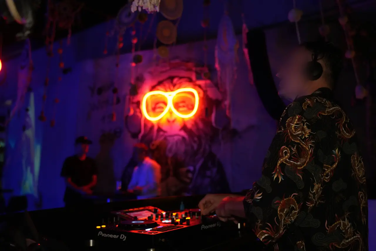 A DJ at the decks in front of the glowing neon wall at 360 Istanbul