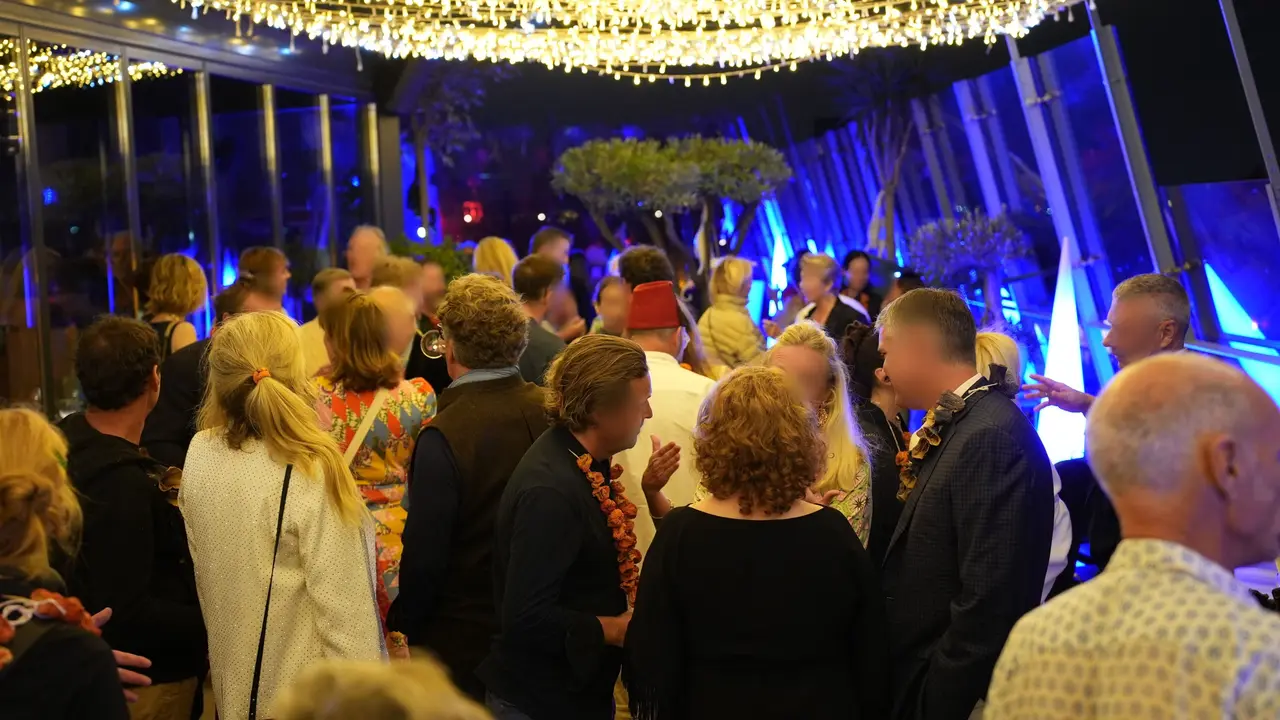 A standing reception under fairy lights on the terrace