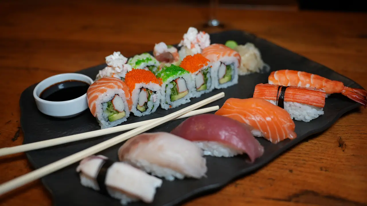 A sushi platter with rolls and nigiri on a dark slate